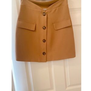 Dark mustard brown skirt above the knee.